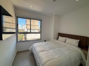 a bedroom with a large bed and two windows at Molas Tower 2 habitaciones in Asuncion