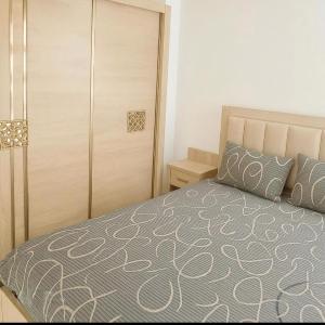 a bedroom with a bed and a wooden closet at Le paradis in Martil