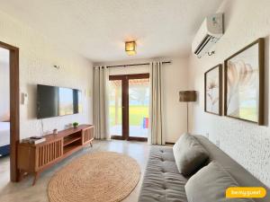 a living room with a couch and a flat screen tv at Reserva Retirinho B in Aracati