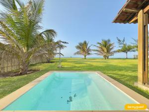 a swimming pool in a yard with palm trees at Reserva Retirinho B in Aracati