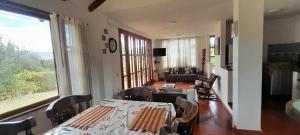a dining room with a table and chairs and a living room at Cabaña Campestre el Refugio in Villa de Leyva