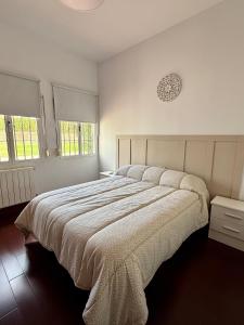 a white bedroom with a large bed and two windows at Mirador De La Vega De Cazalla in Cazalla de la Sierra +40 photos
