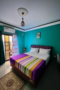 a bed in a room with a green wall at Residence JTC in Douala