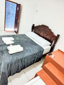 a bedroom with a bed with two towels on it at Quarto Feliz in Belém
