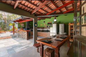 a restaurant with a wooden table and a bar at Casa do Chico 3 suites in Pirenópolis
