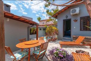 um pátio com uma mesa e cadeiras e uma casa em Casa do Chico 3 suites em Pirenópolis