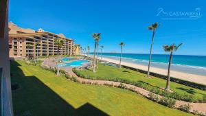Una vista de un resort y la playa con palmeras. en Sonoran Spa W203, en Campo del Medio