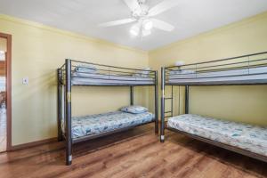 two bunk beds in a room with a ceiling fan at Star of the Sea in Virginia Beach