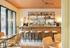 a bar in a restaurant with tables and stools at Hôtel Amista Marseille in Marseille