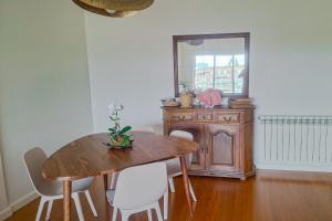 a dining room with a wooden table and a mirror at Sea & City Escape in Matosinhos