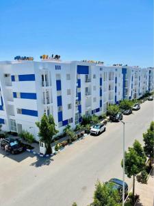 a large white apartment building with a parking lot at Le paradis in Martil