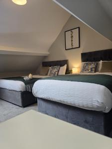 deux lits dans une chambre mansardée avec dans l'établissement The Nook Free Parking Short way City Centre, à Hull