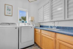 a kitchen with a white refrigerator and a sink at Bella Vista by Gulf Coast Getaways in Pensacola Beach +75 photos