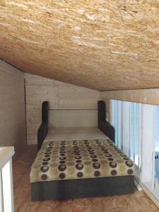 a bed in a room with a wooden ceiling at Maamaja puhkuseks in Kibuna +13 photos