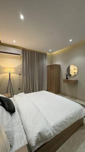 a large white bed in a bedroom with a window at Rest home in Tabuk