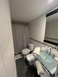 une salle de bain avec un lavabo, des toilettes et un miroir dans l'établissement Oroño Estudio Departamento de 1 habitacion, à Rosario