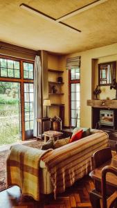 Una sala de estar con un sofá y una chimenea. en The River Villa, en Magaliesburg