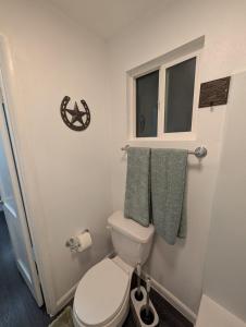 a small bathroom with a toilet and a window at Rancho Las Casitas in Tucson