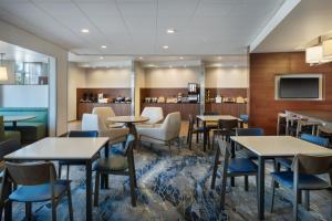 a restaurant with tables and chairs and a tv at Fairfield Inn & Suites by Marriott Lincoln Southeast in Lincoln