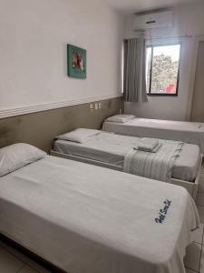 a group of three beds in a room at Hotel Serra Sol in Serrinha