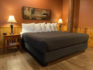 een slaapkamer met een groot bed met twee tafels en twee lampen bij Timberline Lodge - Arnold - Bear Valley - Murphys in Arnold