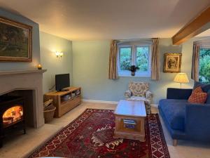 a living room with a couch and a fireplace at Kissingstone Cottage - Hidden Gem! in Stroud