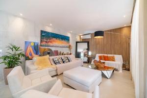 a living room with white furniture and a painting on the wall at Casa Atalaia 550m Praia c/ Hidro by Achei Camboriú in Praia Brava