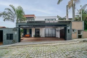 a house with a brick driveway in front of it at Casa Atalaia 550m Praia c/ Hidro by Achei Camboriú in Praia Brava