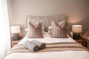 a bed with two pillows and two towels on it at 222 at Maine in Pretoria +37 photos