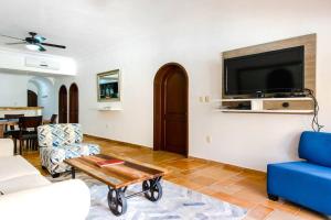 阿文图拉斯港Dina | 2BR | Condo | Puerto Aventuras的墙上挂着电视的客厅