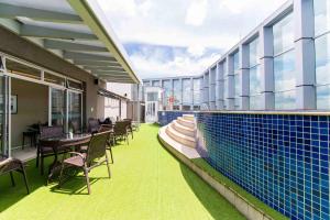 巴西利亚Vision Hotel em Brasília 84573的一个带椅子的阳台和一个位于大楼内的游泳池