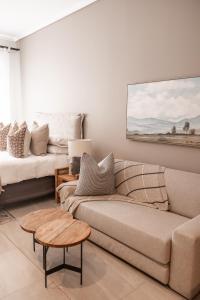 a living room with a couch and a table at 222 at Maine in Pretoria