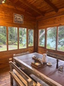 a dining room with a table in a wooden cabin at Patagonia Krugger Lodge in Trevelin