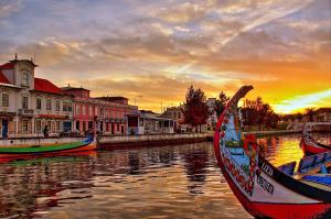 a group of boats sitting in the water at sunset at Smart Living in Aveiro