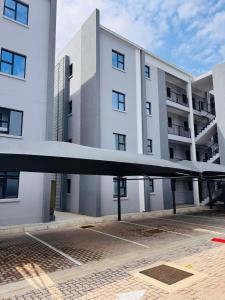 a large white building with a large wing in front of it at Kastina Suites at The Fig in Gaborone +2 photos