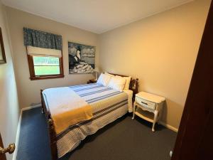 a small bedroom with a bed and a window at Brookhaven 5 in Maple City