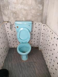 a bathroom with a blue toilet in a stall at shnongpdeng tents stay in Dawki