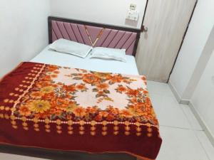 a bed in a room with a blanket on it at Hotel Dream in Rajkot