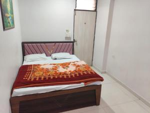 a bedroom with a bed with a red blanket on it at Hotel Dream in Rajkot