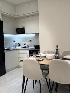 a kitchen with a wooden table and chairs and a kitchen with a refrigerator at Chic Apartament Free Parking in Vlorë