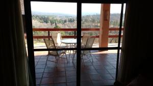 - Balcón con vistas a una mesa y sillas en El Refugio De Posta en Santa Rosa de Calamuchita