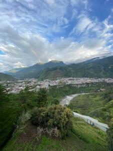 Blick auf eine Stadt von einem Hügel mit einem Regenbogen in der Unterkunft Freestyle House Hostel in Lligua