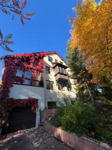 a white house with red ivy growing on it at Prime Home SOPOT HILL in Sopot