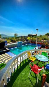 a balcony with a table and chairs next to a swimming pool at BFMS Villa, Royal Purandar in Purandhar