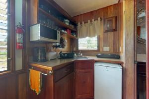 a small kitchen with wooden cabinets and a microwave at Starfish Cabana at Latitude Adjustment -Gold Standard Certified in Hopkins +14 photos