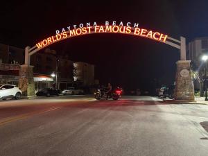 a sign for a beachlords most famous beach at night at Amazing Studio Steps Away From The Atlantic Ocean! in Daytona Beach