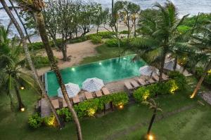 an aerial view of a swimming pool and the beach at Naomi Beach Resort - Adults only in Weligama
