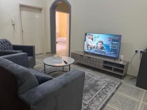 Una sala de estar con dos sofás y un televisor de pantalla plana. en ANA Apartment, en Hail