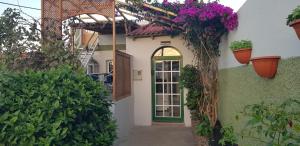 a building with flower pots on the side of it at Guesthouse Los Geranios in Mocanal