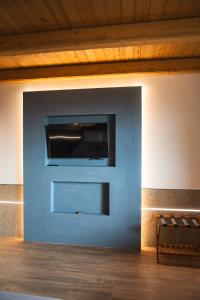 uma parede branca com uma televisão de ecrã plano em Agriturismo Dai Dellerba em Pinerolo